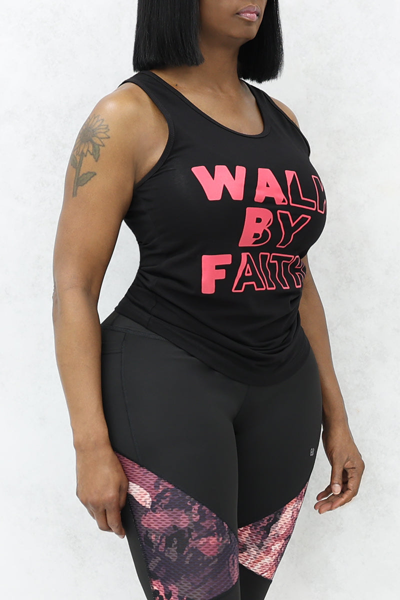 A woman wearing black tank top with pink color "Walk by Faith" text on it and black-pink tights.