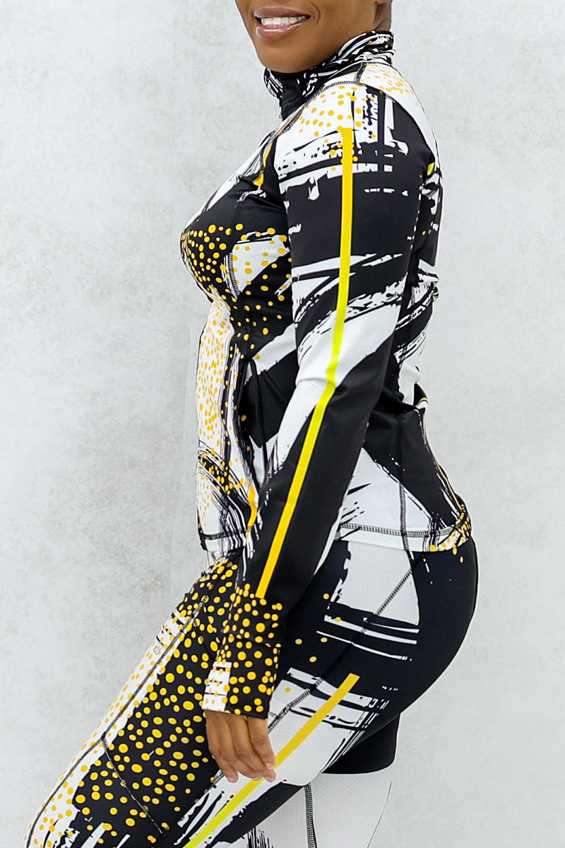 a woman wearing a fitted fitness jacket printed with a black, gold, and white abstract design.