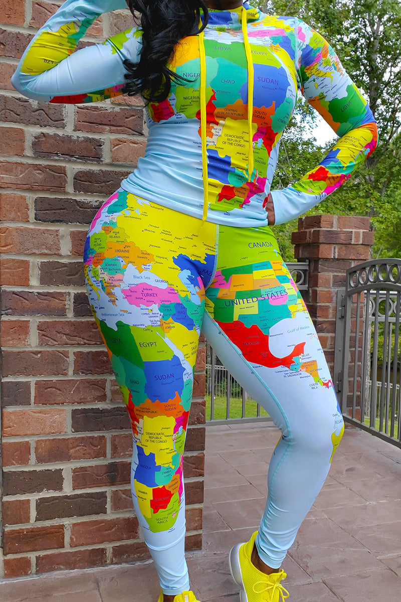 A woman wearing a fitted fitness blue tights and matching pullover printed with world's map design with pink sneakers.