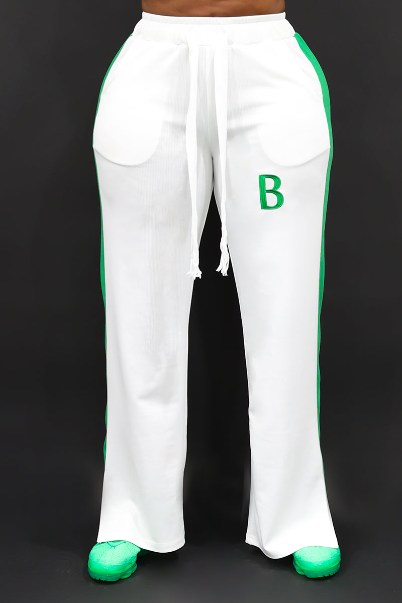 A happy woman wearing White and green B-Girl sweatpants with a comfortable, sporty style.
