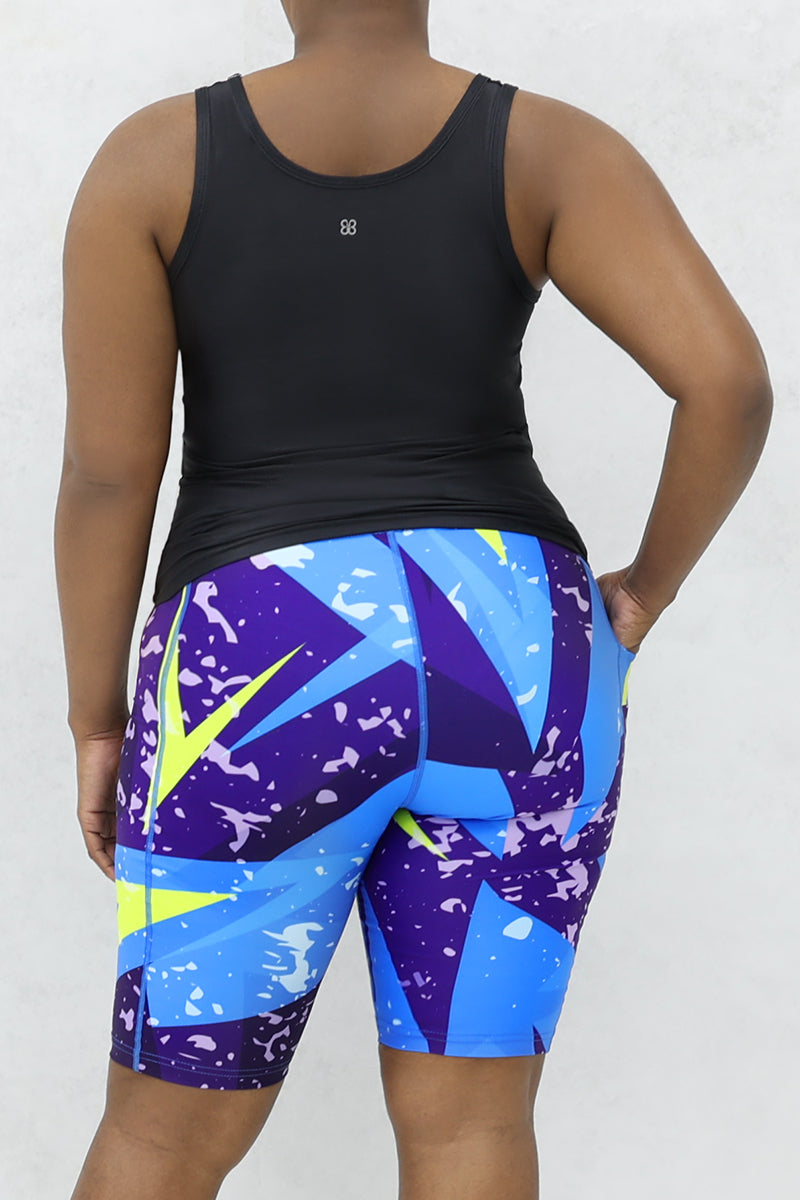 A stylish woman wearing a multi-colored Fusion Fly tank top.
