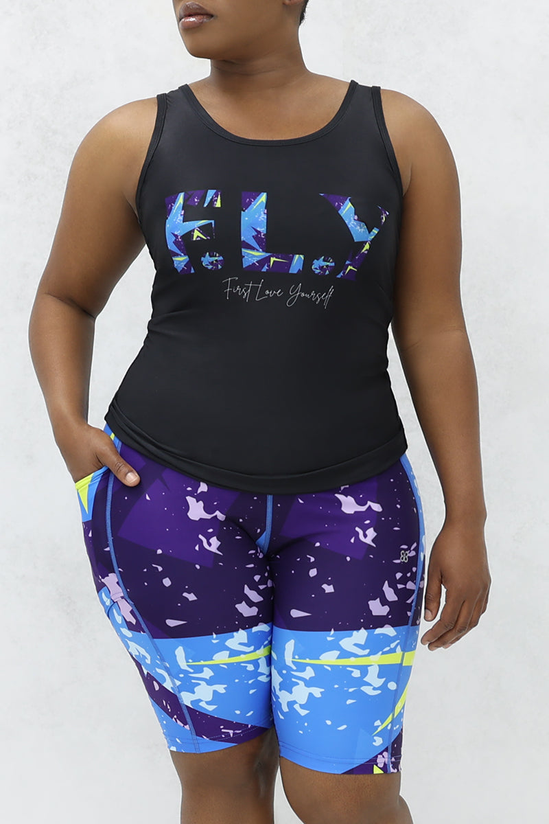 A stylish woman wearing a multi-colored Fusion Fly tank top.