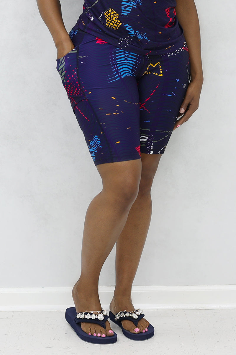 A stylish woman wearing multi-colored Genius shorts.