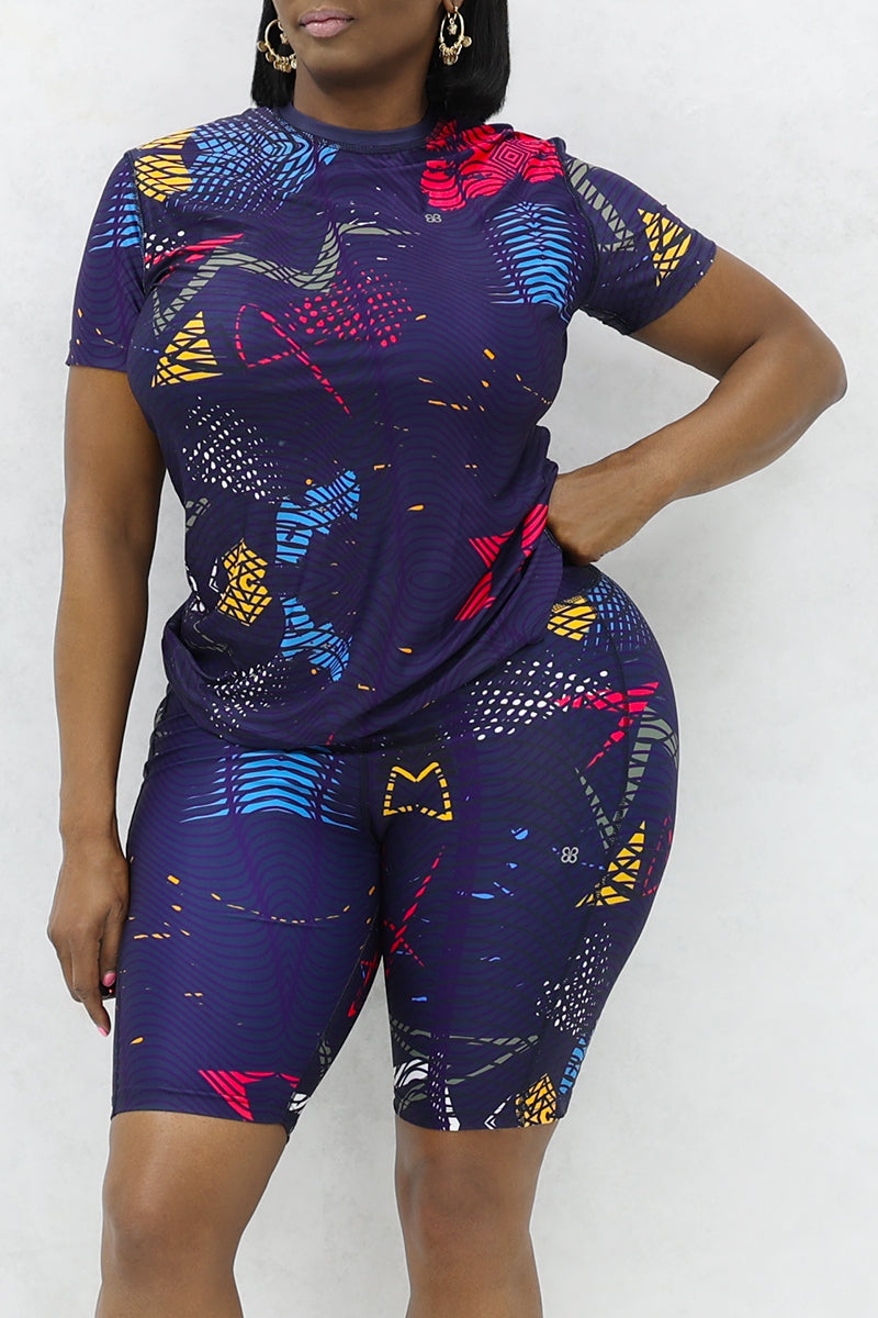 A confident woman wearing a multi-colored Genius t-shirt.