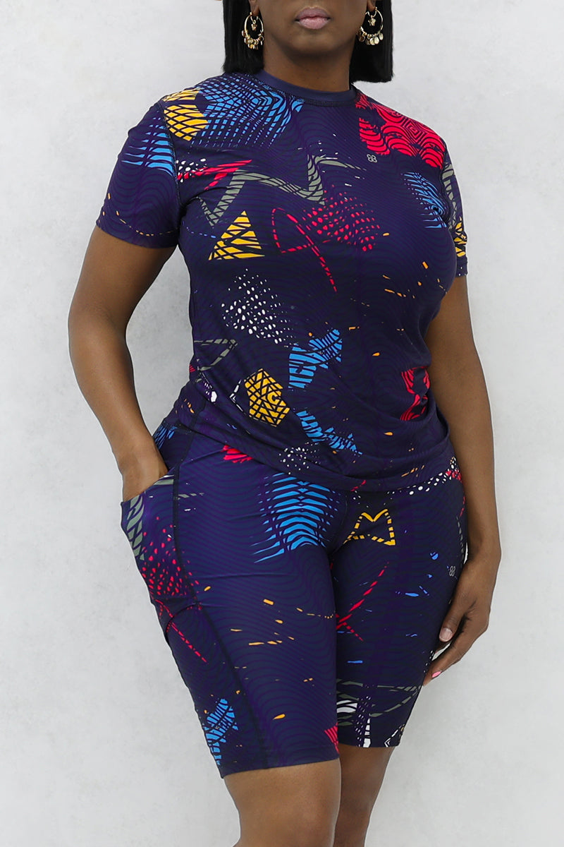 A confident woman wearing a multi-colored Genius t-shirt.