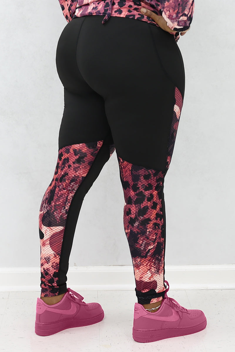 A woman wearing black and pink Graphic tights featuring printed panels and a continuous drawstring for a secure fit.