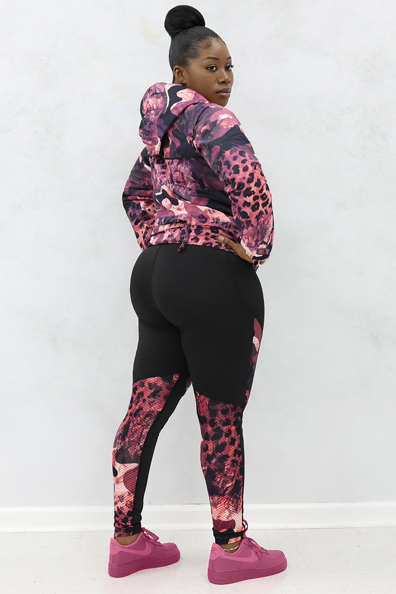 A woman wearing black and pink Graphic tights featuring printed panels and a continuous drawstring for a secure fit.