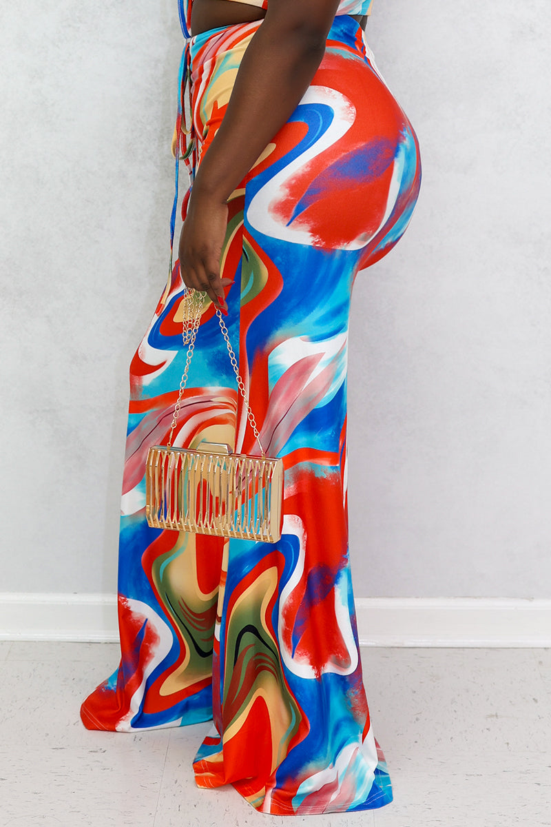 A woman wearing a high-waisted, multi-colored Mixed Print Skirt with a bold swirl design, stretchy fabric, and a drawstring for a comfortable fit.