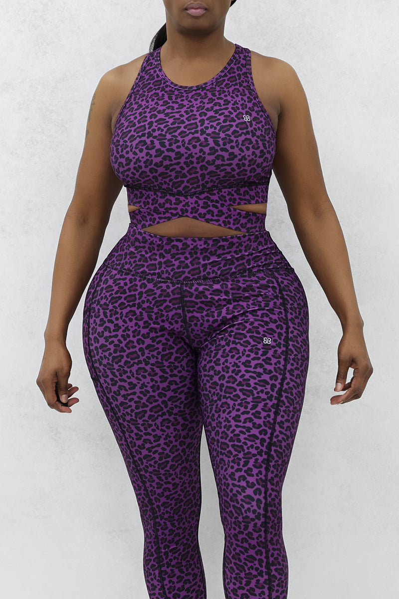 A woman wearing Purple sports bra featuring a stylish cheetah print design.