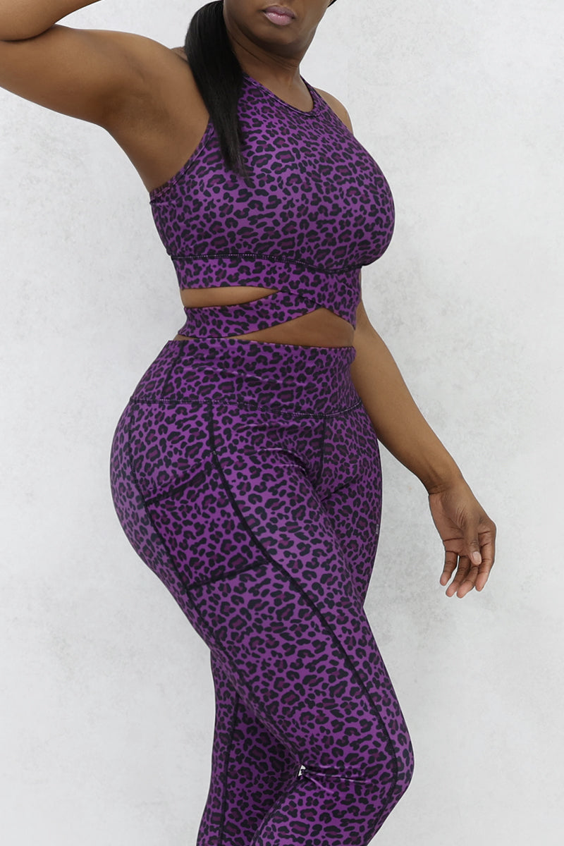 A woman wearing Purple sports bra featuring a stylish cheetah print design.