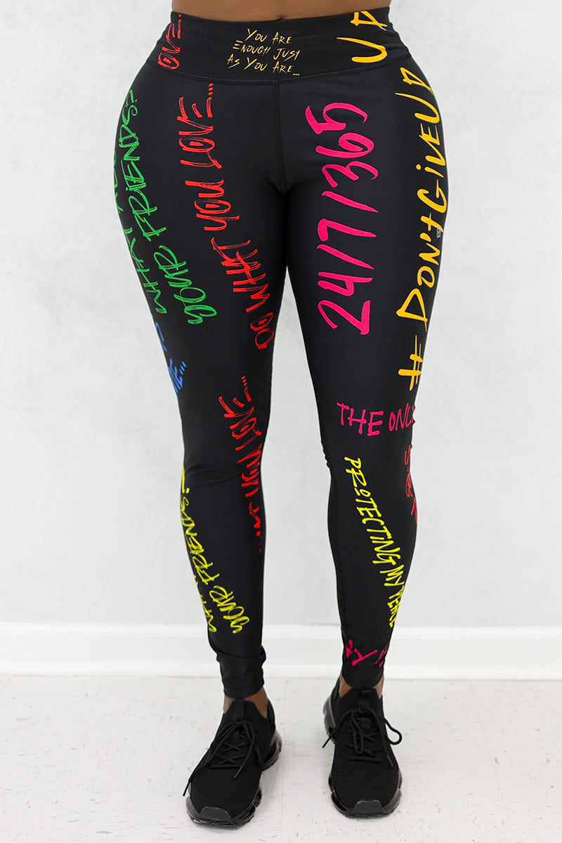 A woman wearing Quote Tights in black with multi-colored inspiring quotes, designed with durable, stretchy fabric and a continuous drawstring for comfort during workouts.