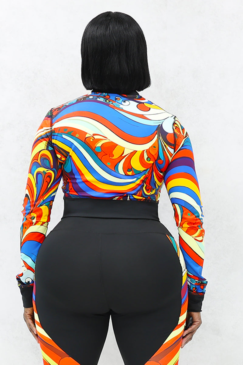 A woman wearing a multi-colored Slit Back Long Sleeve top with vibrant swirl patterns, featuring a snug fit and stylish design ideal for workouts or casual outings.