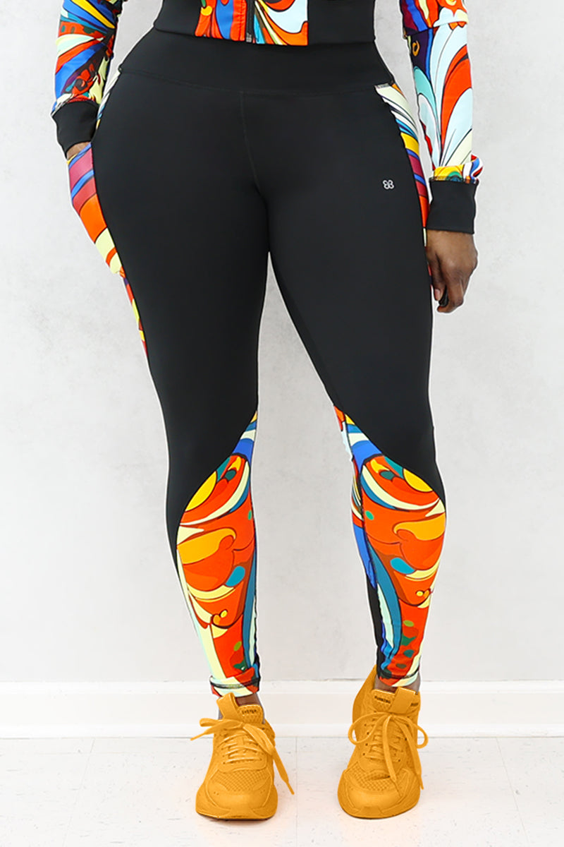 A woman wearing multi-colored Soul Train Tights featuring sleek black fabric with vibrant retro patterns, designed for comfort and performance during workouts or everyday activities.