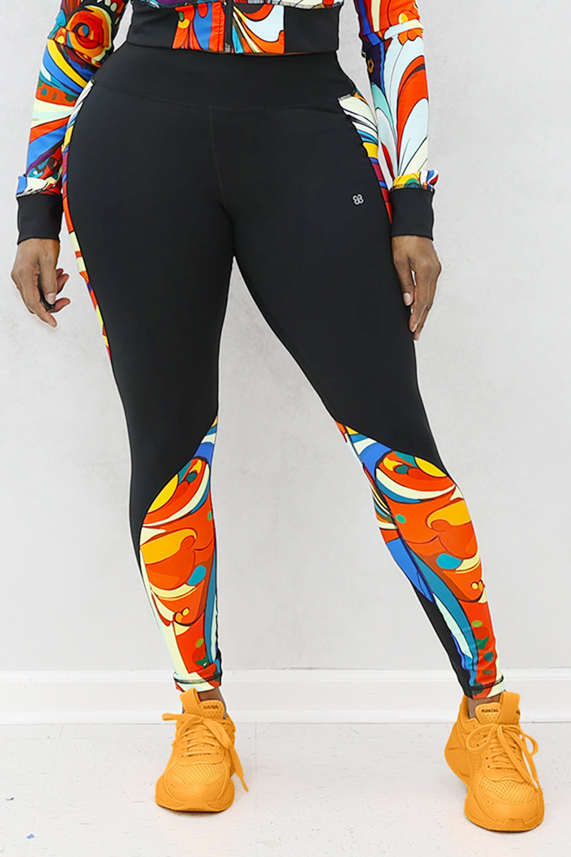 A woman wearing multi-colored Soul Train Tights featuring sleek black fabric with vibrant retro patterns, designed for comfort and performance during workouts or everyday activities.