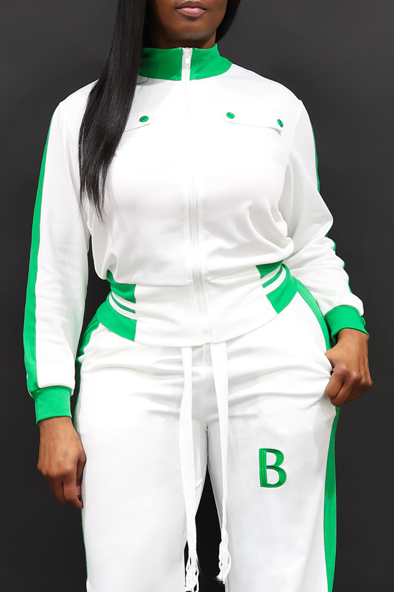 A woman wearing a White and green full zipper jacket with white sweatpants.
