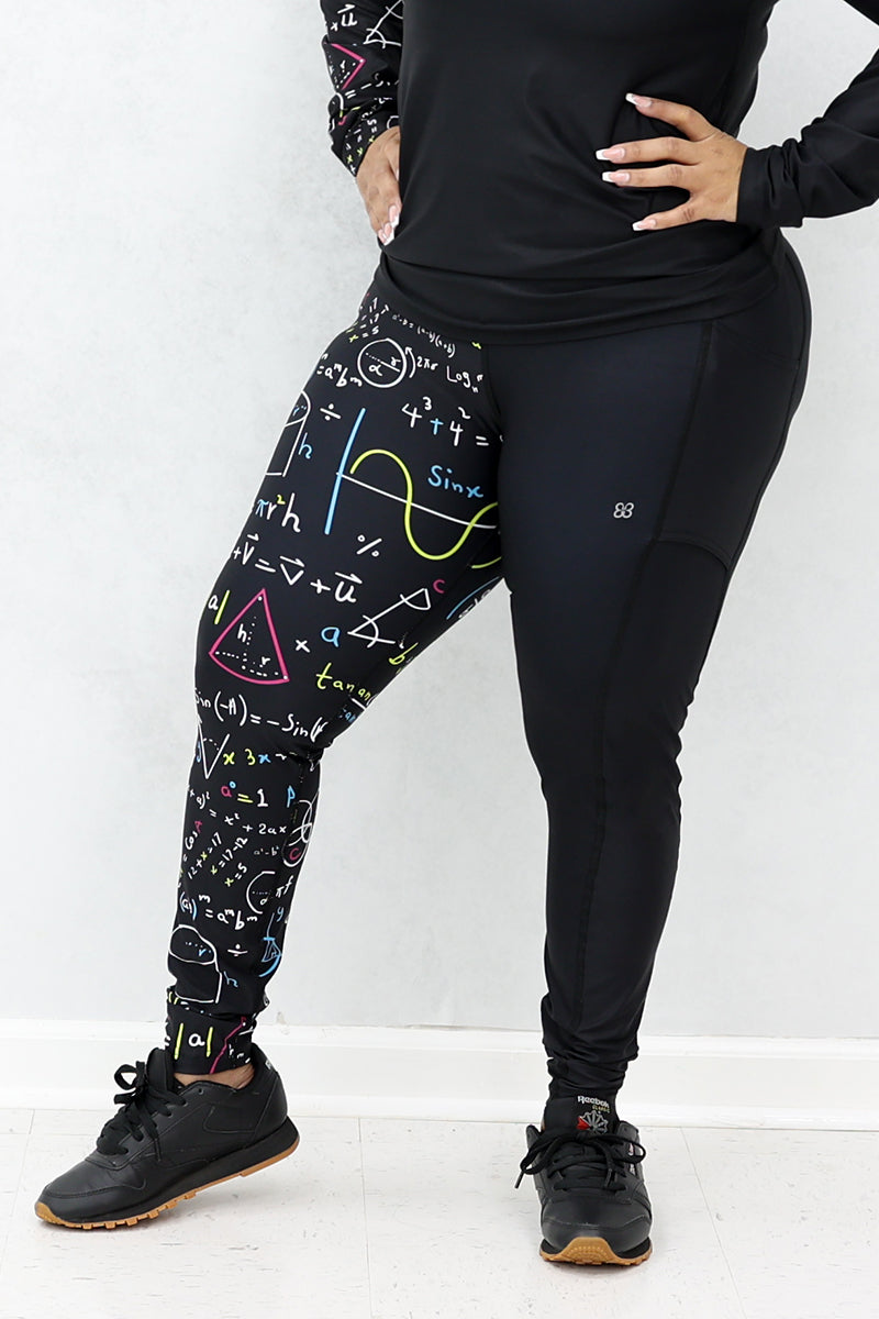 A woman wearing black tights with multicolor math equations printed on one side and black shoes.