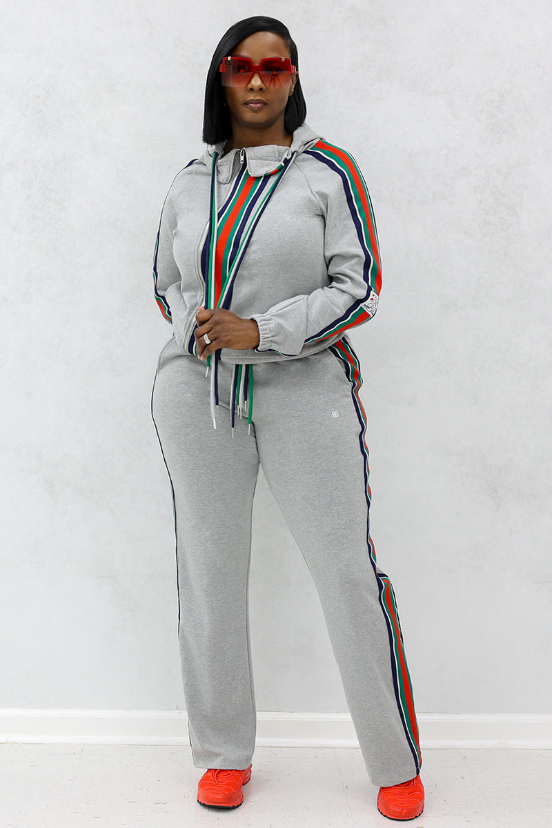 Woman wearing red sunglasses, gray front stripe hooded jacket and side stripe joggers with pockets