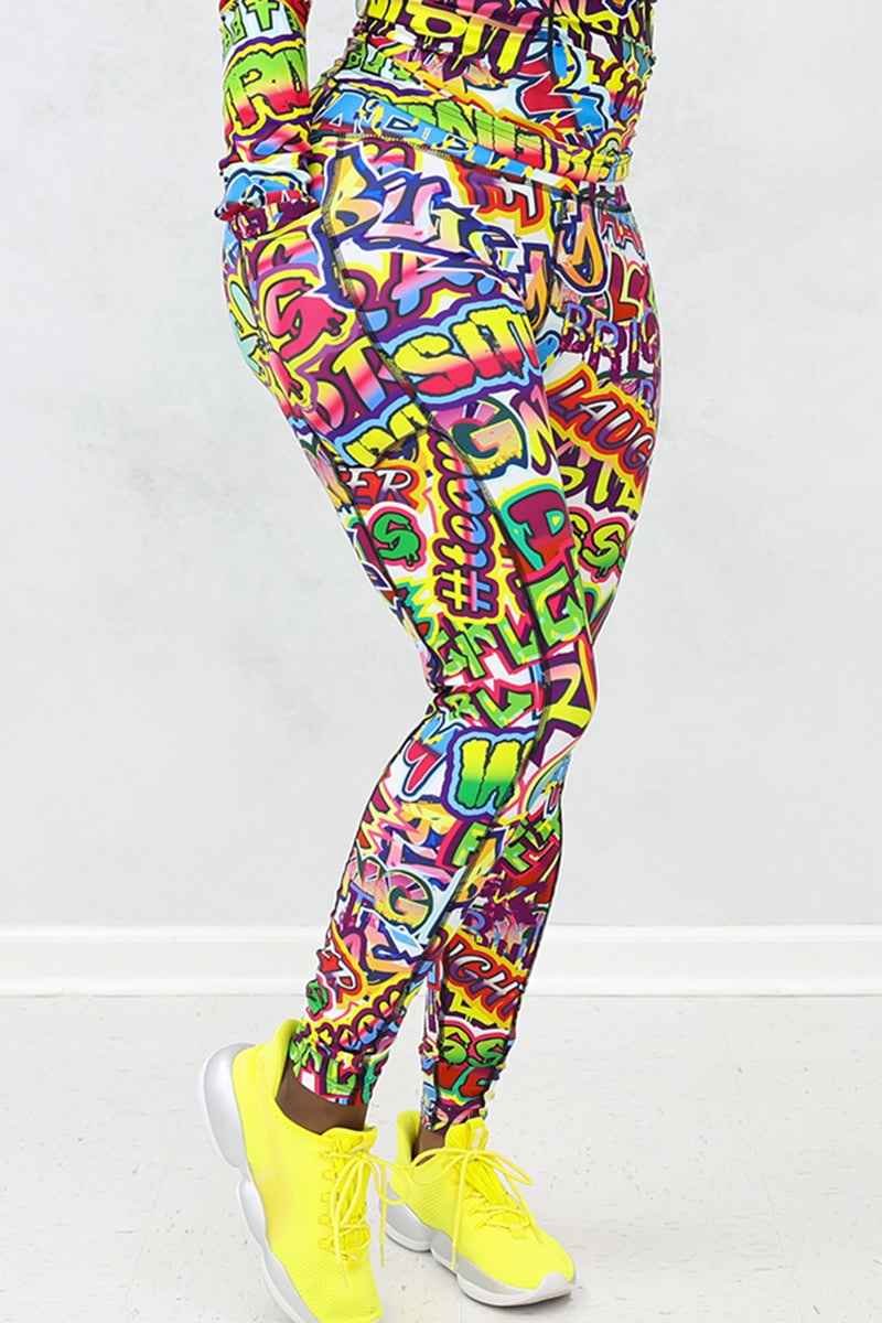 A woman wearing multi-colored Graffiti tights featuring a unique design, side pockets, and a stretchy fit, ideal for workouts.