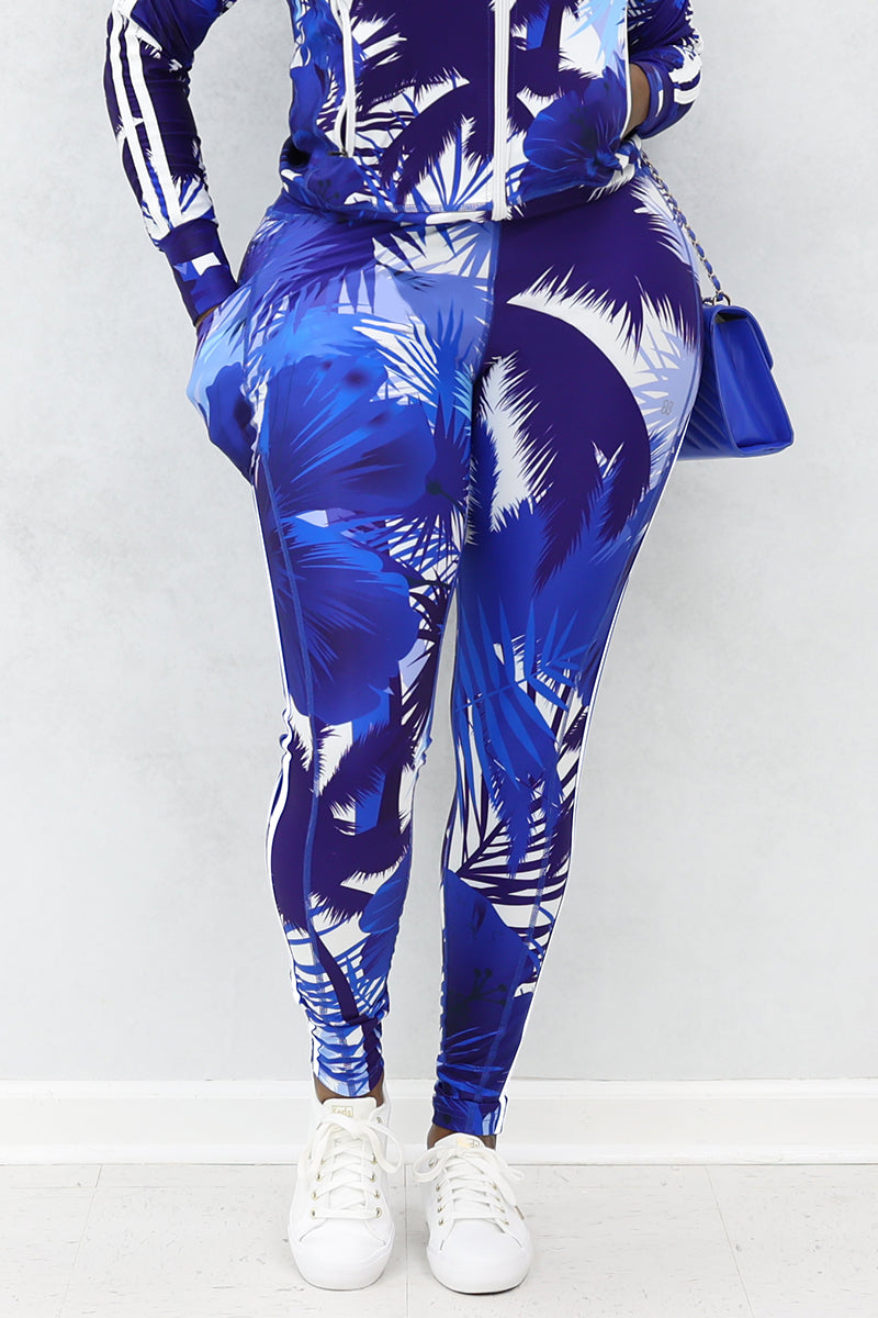A woman wearing blue and white tropical printed tights with pockets and white shoes.
