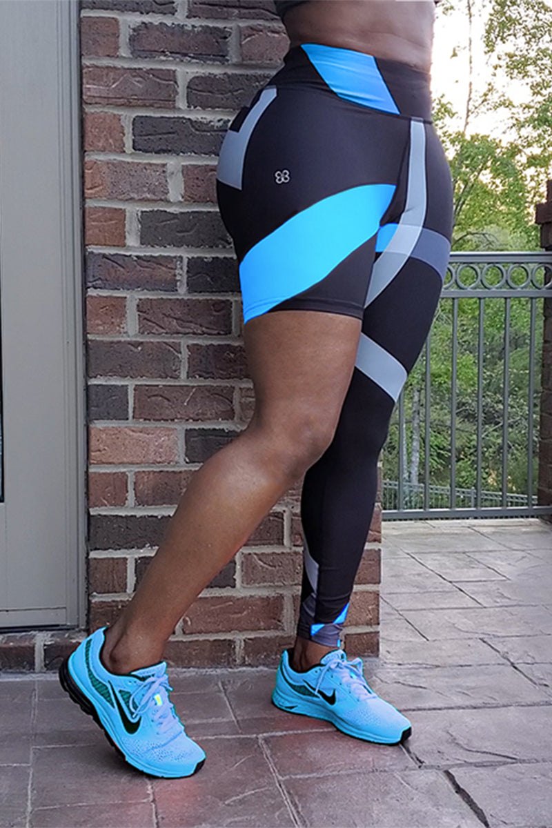 A woman wearing unique one-legged tights featuring vibrant ombre colors in aqua-blue, designed for individuality and comfort during workouts.
