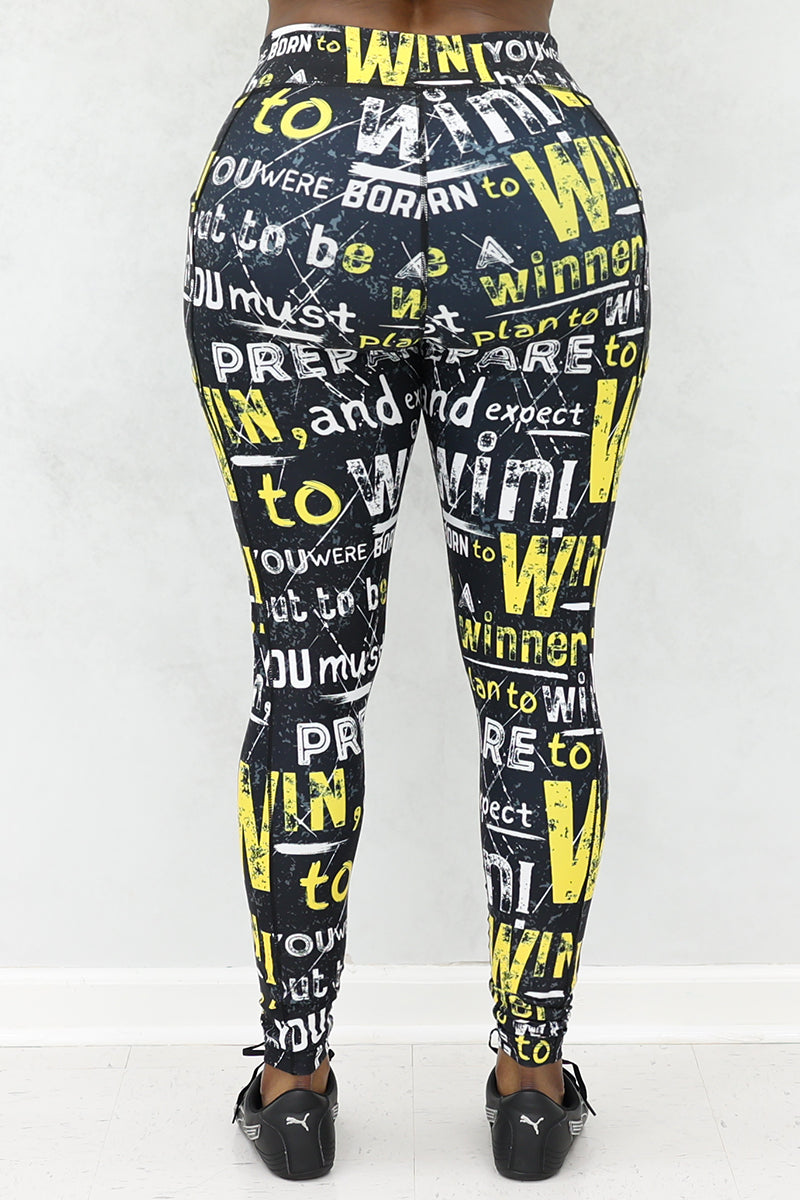 A woman wearing black tights with Prepare to Win yellow and white bold print and black shoes.