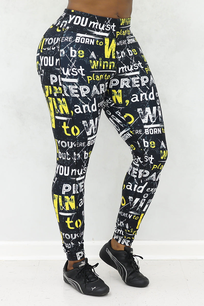 A woman wearing black tights with Prepare to Win yellow and white bold print and black shoes.