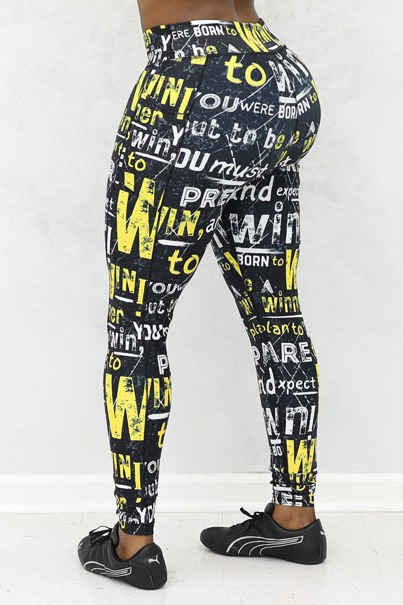 A woman wearing black tights with Prepare to Win yellow and white bold print and black shoes.