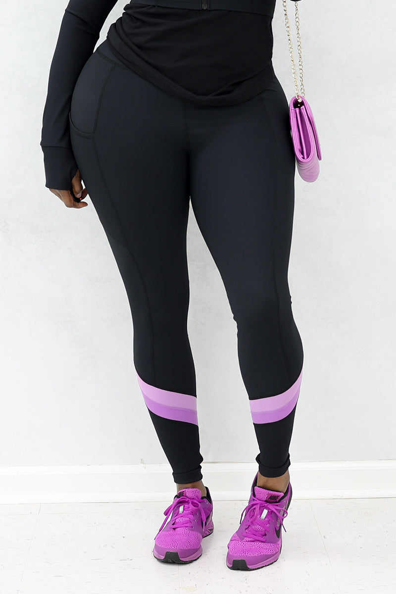A woman wearing black and purple Ribbed Panel tights with purple shoes and a purse.