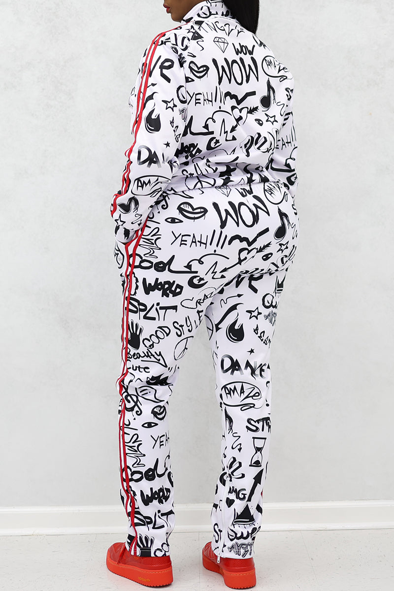 A woman wearing graffiti-print tracksuit with red stripes and shoes.