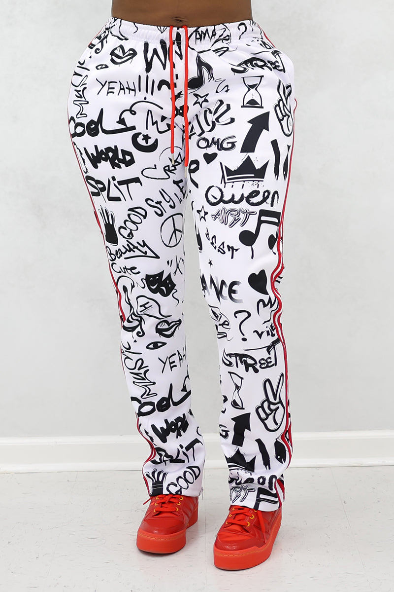 Wearing relaxed fit Street Sweatpants with black graffiti doodles and words like Yeah, Queen, and World. Featuring red side stripes, these fleece pants are styled with red sneakers for a standout look.