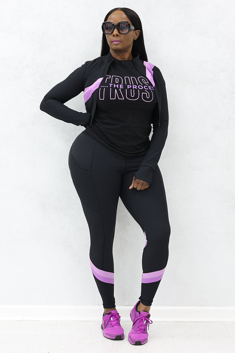 A woman wearing a black and purple Ribbed Panel Cropped Jacket with full zip and stand-up collar along with purple shoes and black sunglasses.