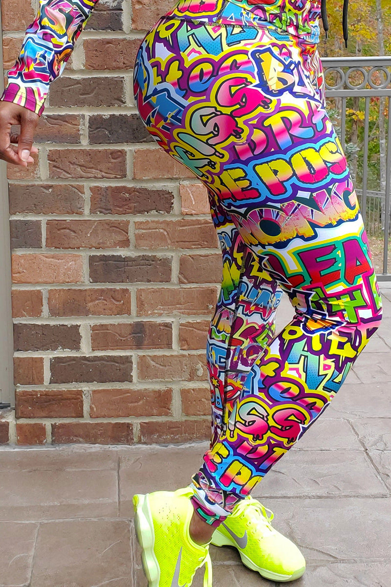 A woman wearing multi-colored Graffiti tights featuring a unique design, side pockets, and a stretchy fit, ideal for workouts.