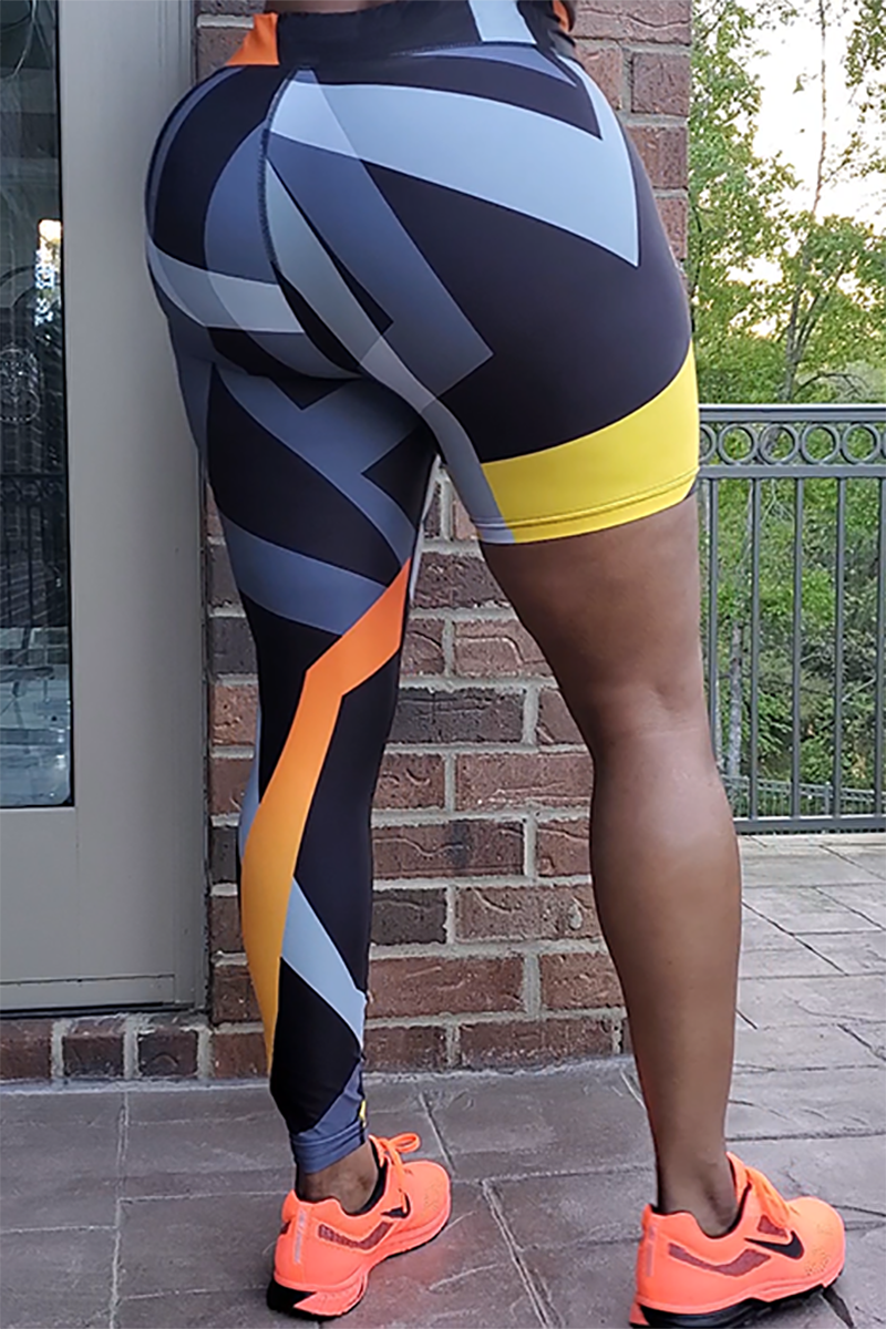 A woman wearing unique one-legged tights featuring vibrant ombre colors in orange-yellow, designed for individuality and comfort during workouts.