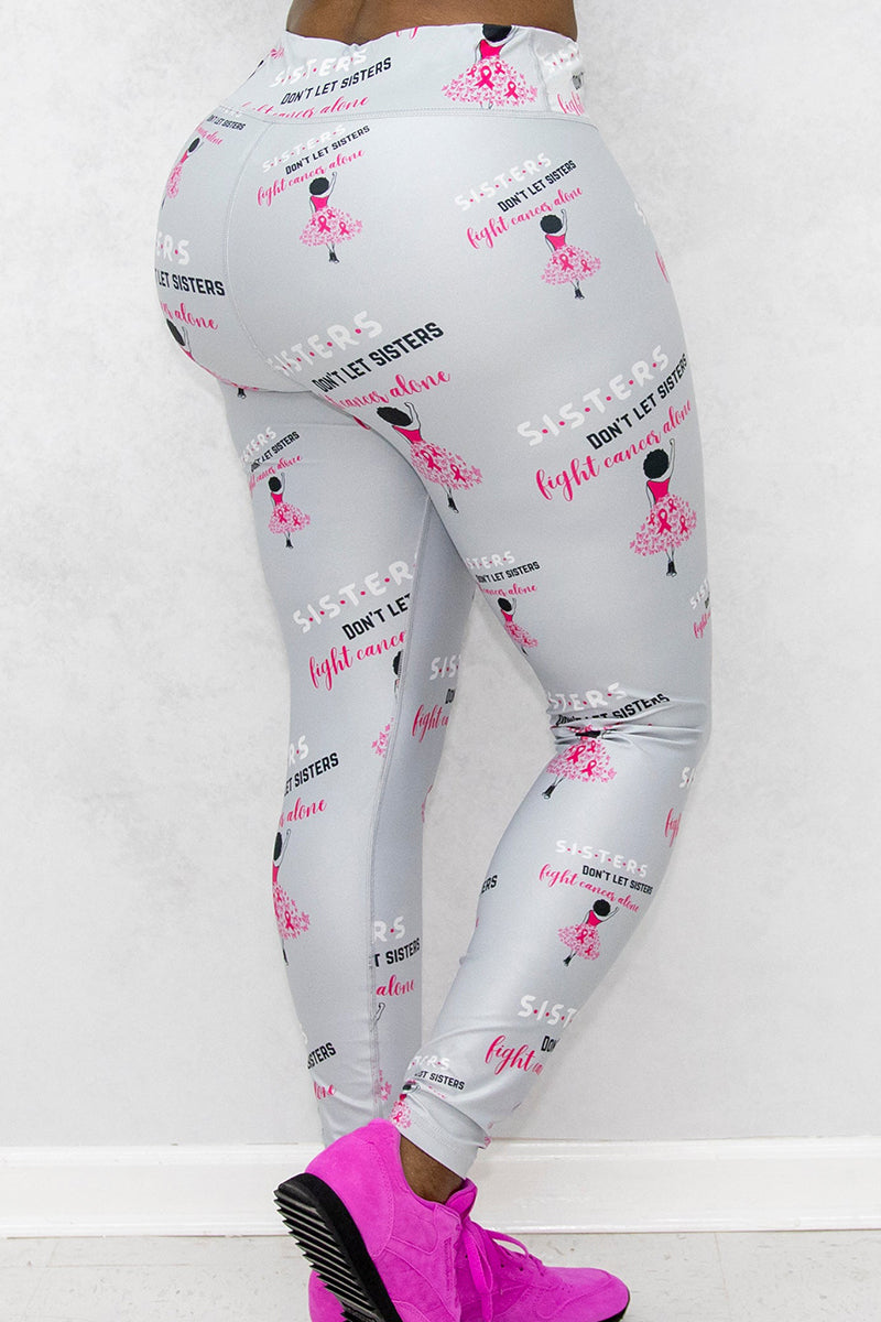 A woman wearing Sisters Don't Let Sisters Tights in silver, featuring a stylish design that promotes Breast Cancer awareness while providing comfort for various activities.