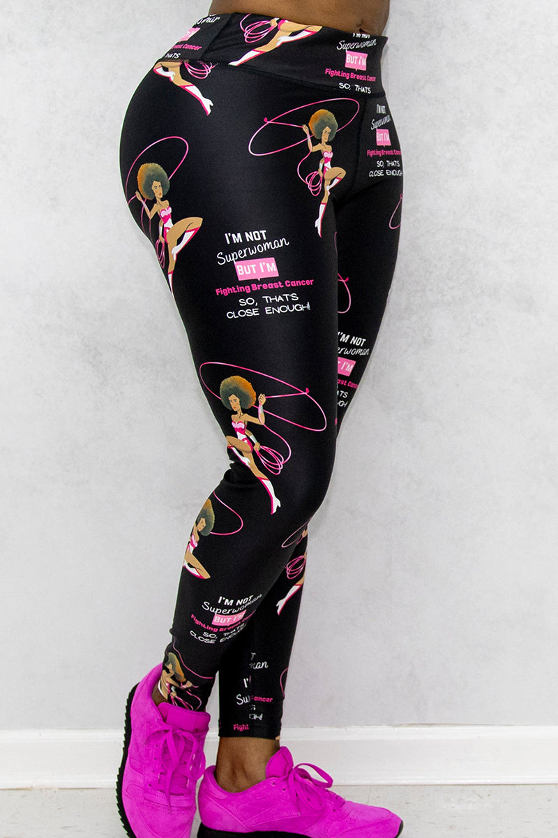 A woman wearing black tights with Breast Cancer Awareness prints and pink shoes.