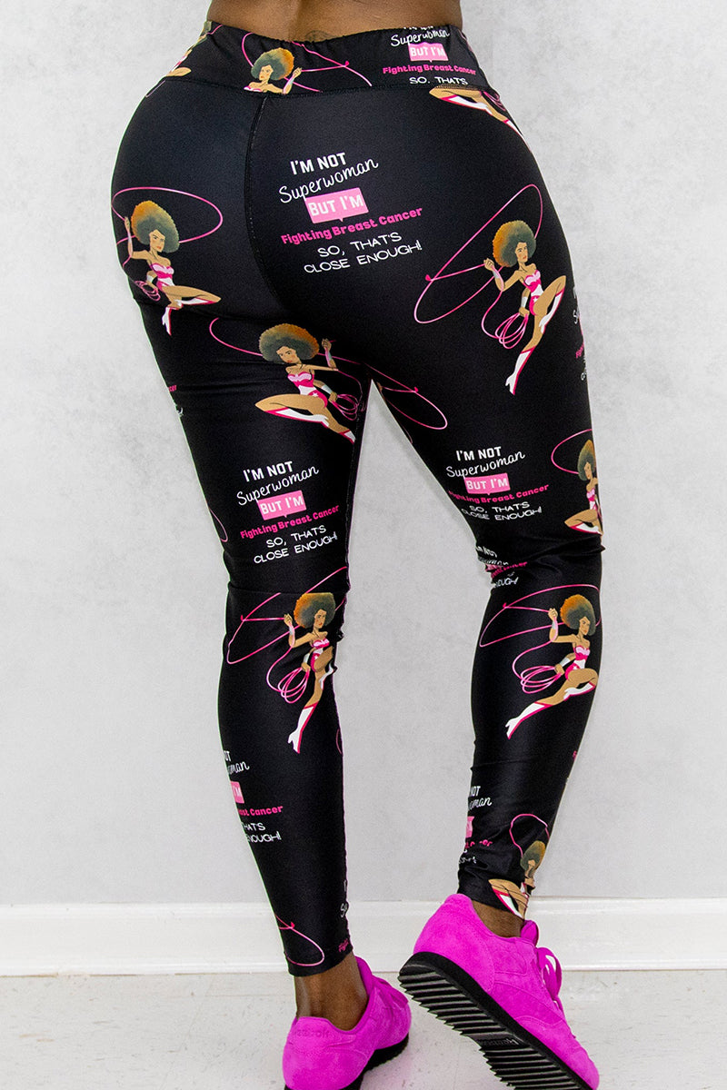 A woman wearing black tights with Breast Cancer Awareness prints and pink shoes.