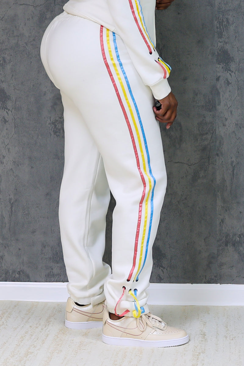 A person wearing white shoe string joggers with white shoes.