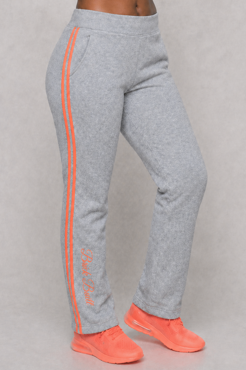 A person in Grayline Sweatpants (SAMPLE), gray with peach side stripes and "Black Built" text near the ankle, paired with bright orange sneakers stands against a plain background—ideal for any sample sale featuring discounted pants.