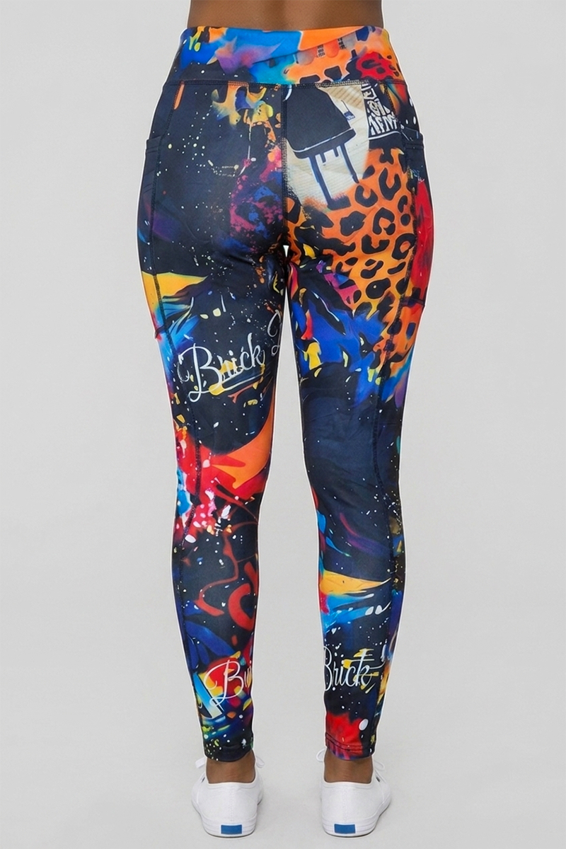 Wearing the Art Code Tights, a person stands with their back to the camera against a plain, light background. These high-waisted leggings feature vibrant, graffiti-inspired patterns—including animal prints and the word “Brick”—and are crafted from a soft polyester-spandex blend with 4-way stretch for comfort and flexibility.