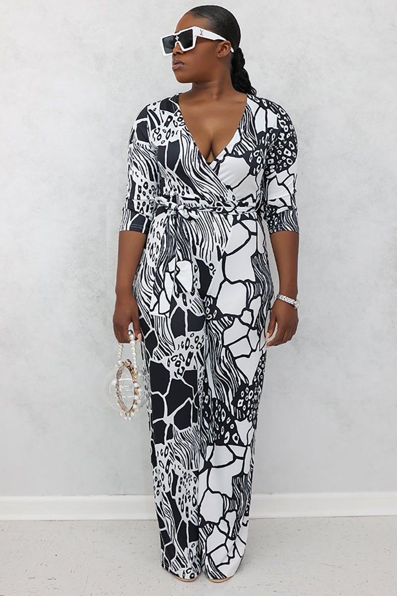 A woman wearing black and white jumpsuit featuring a stylish, contemporary design.