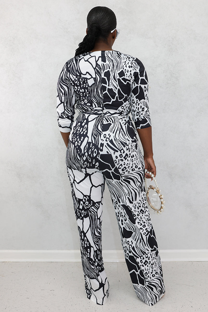 A woman wearing black and white jumpsuit featuring a stylish, contemporary design.