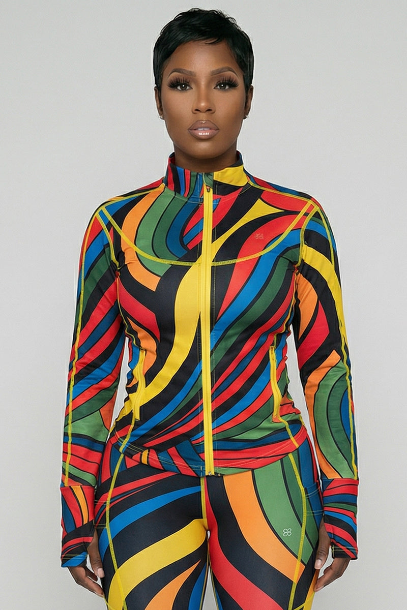 A person faces forward, wearing the fitted, long-sleeve Color Riot Jacket with thumbhole sleeves and matching pants, both featuring a bold, multicolored swirling pattern in red, blue, yellow, green, orange, and black.