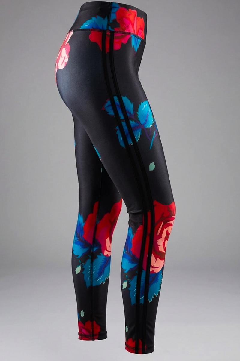 The Red Roses Tights are black stretchy leggings with a vibrant floral pattern of large red and pink flowers and blue-green leaves, shown on a mannequin against a plain gray background.
