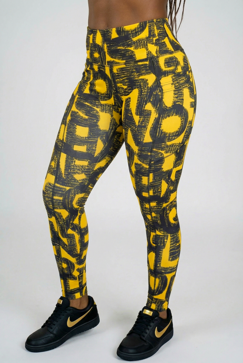 A woman wearing Black & Yellow Tights made from lightweight, breathable fabric.