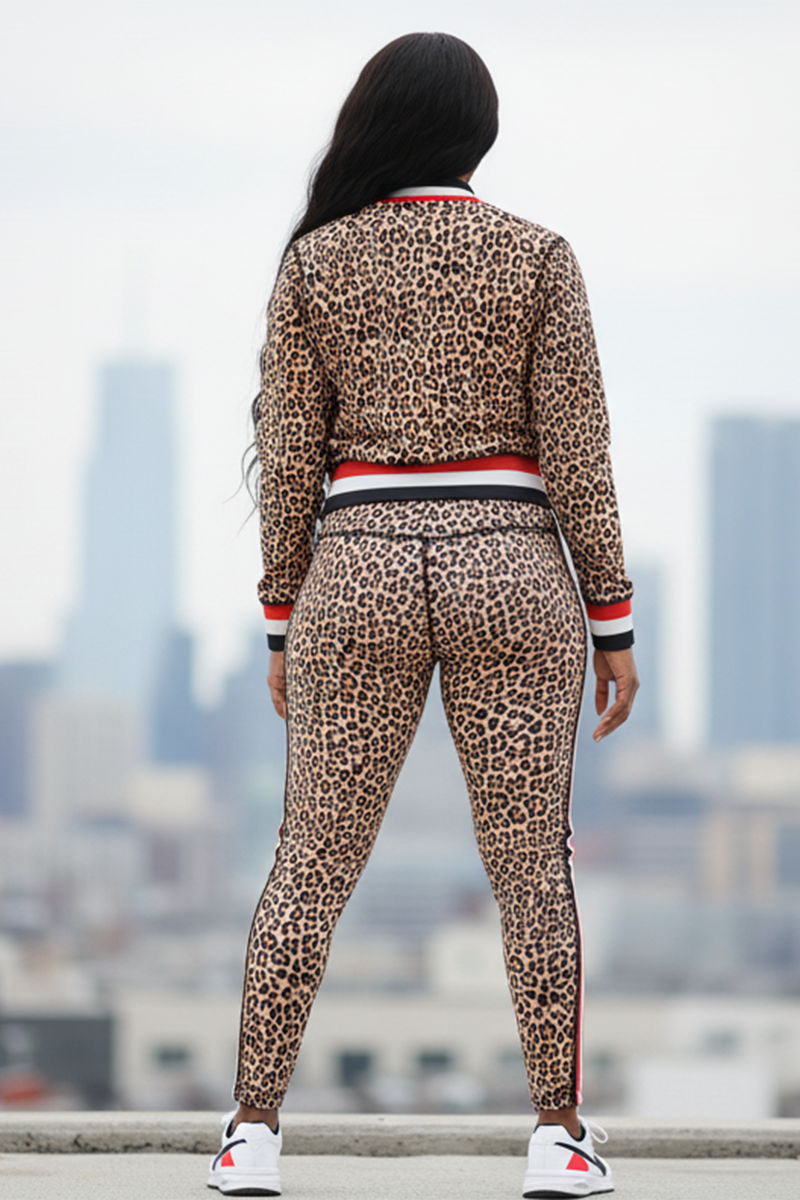 A person with long dark hair stands with their back to the camera, wearing Ona High-Waisted Tights and a matching leopard print jacket, paired with white sneakers. A city skyline of tall buildings appears in the background.