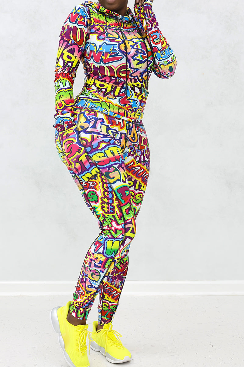 A woman wearing a multi-colored Graffiti hooded pullover with a unique design, perfect for workouts and casual wear.