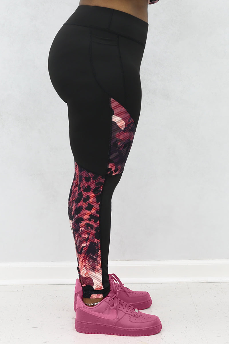 A woman wearing black and pink Graphic tights featuring printed panels and a continuous drawstring for a secure fit.