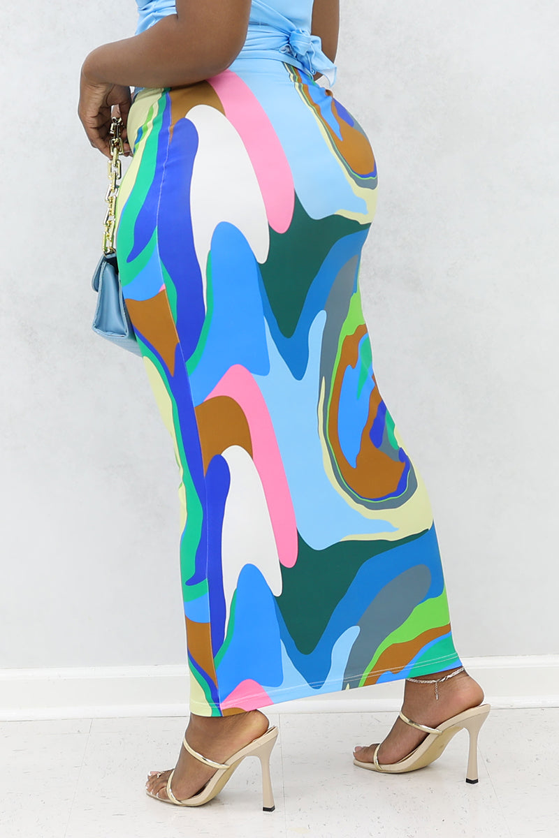 A woman wearing a multi-colored Groove midi skirt, featuring a stretchy pencil design and an elastic waistband.