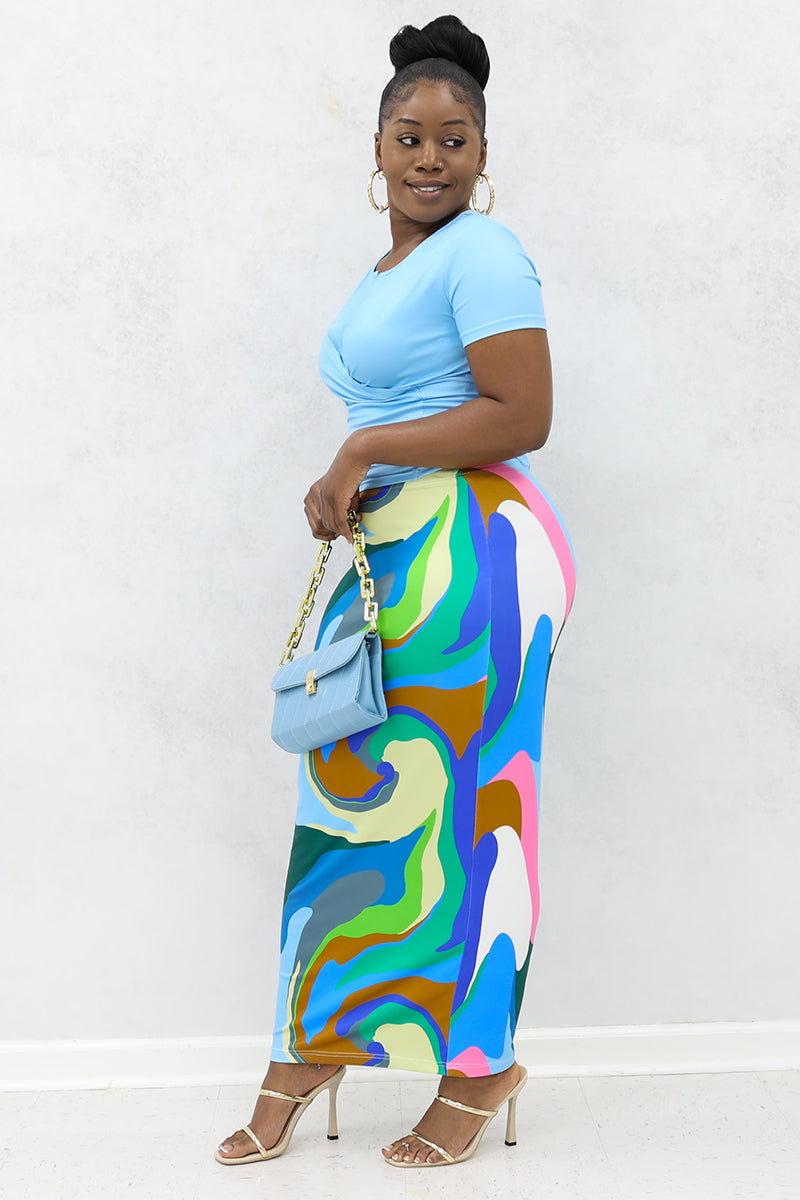 A woman wearing a multi-colored Groove midi skirt, featuring a stretchy pencil design and an elastic waistband.