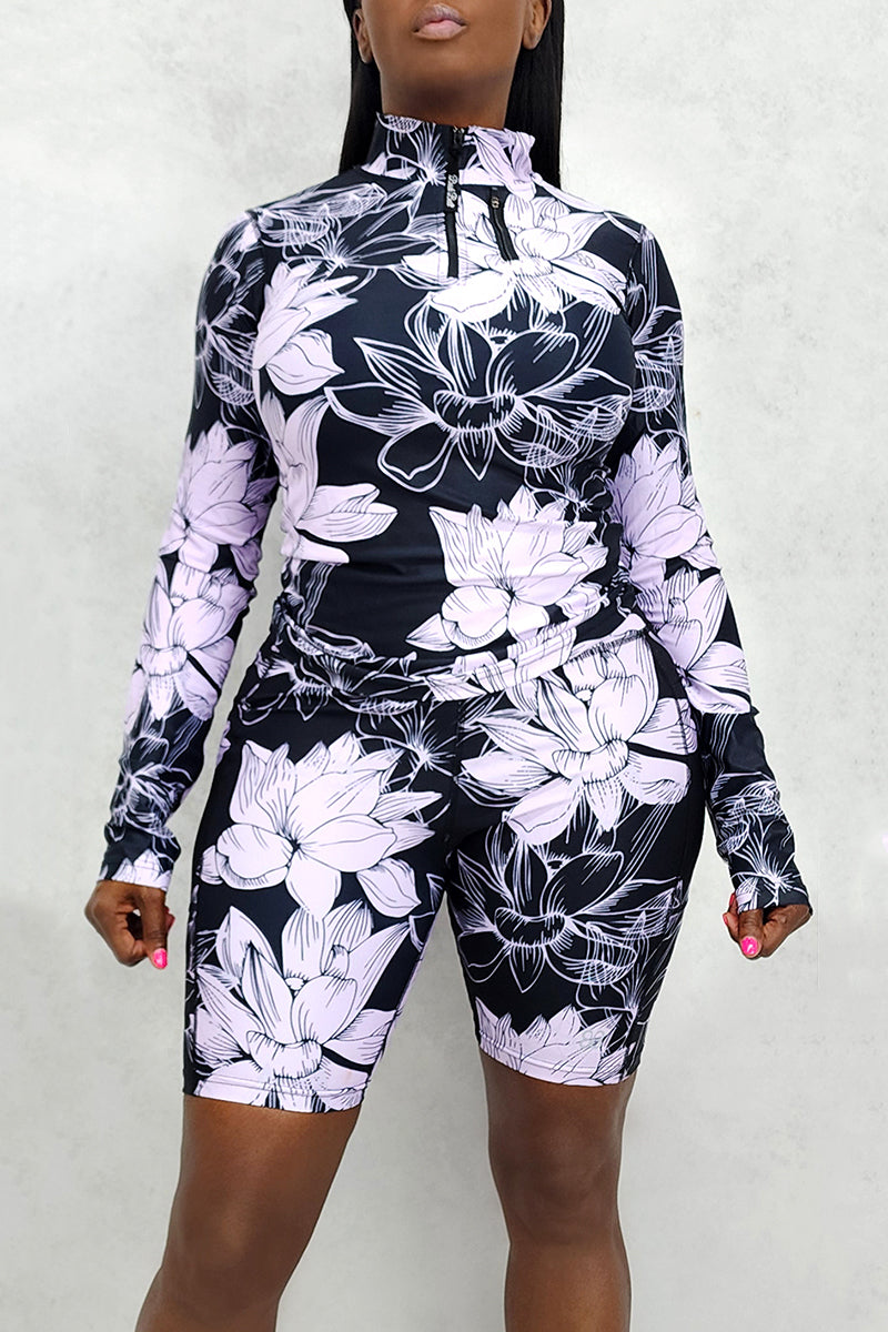 A woman wearing a lavender floral pullover featuring a bold feminine floral pattern and a sporty silhouette, showcasing a stylish and confident look.